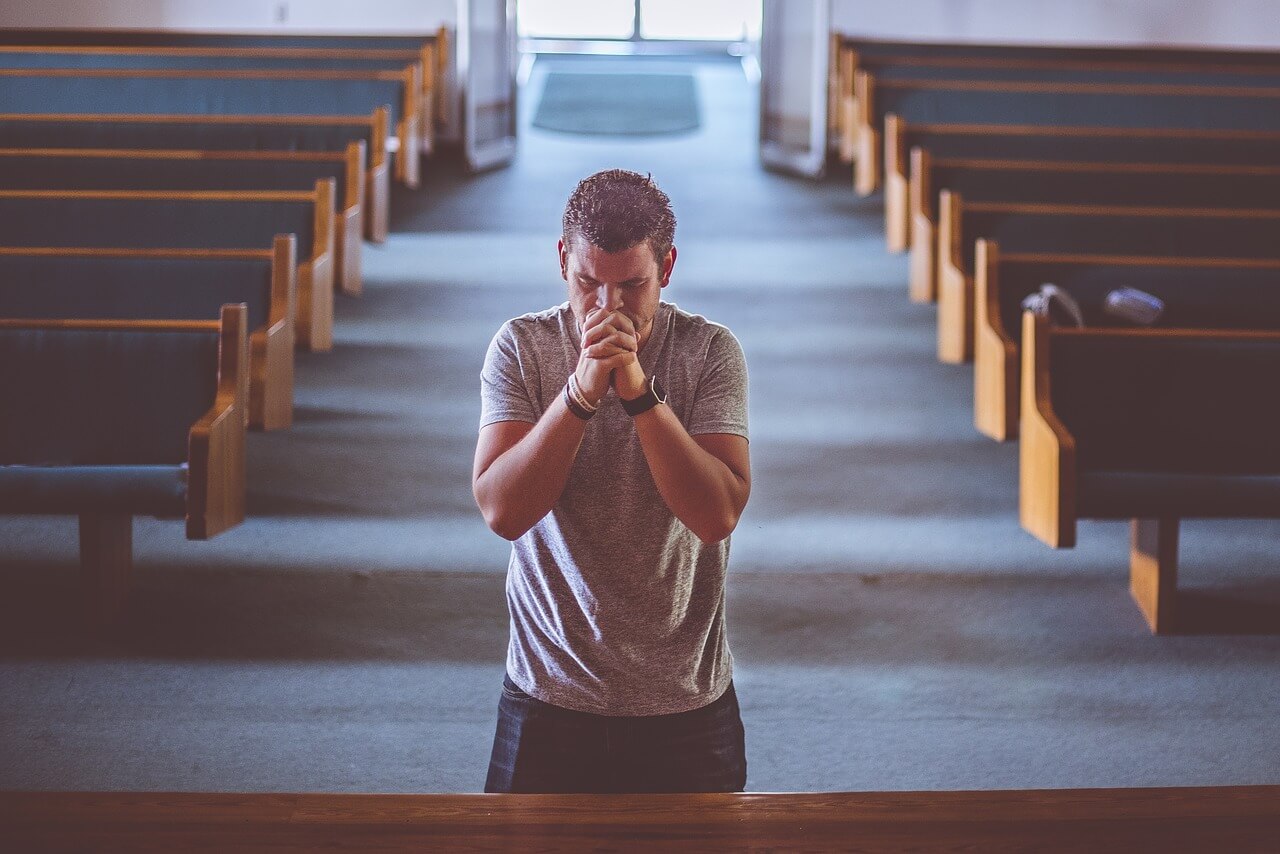 mladić se moli u crkvi