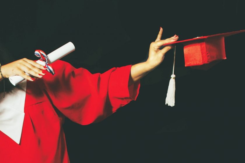 student u svečanoj halji drži diplomu u ruci