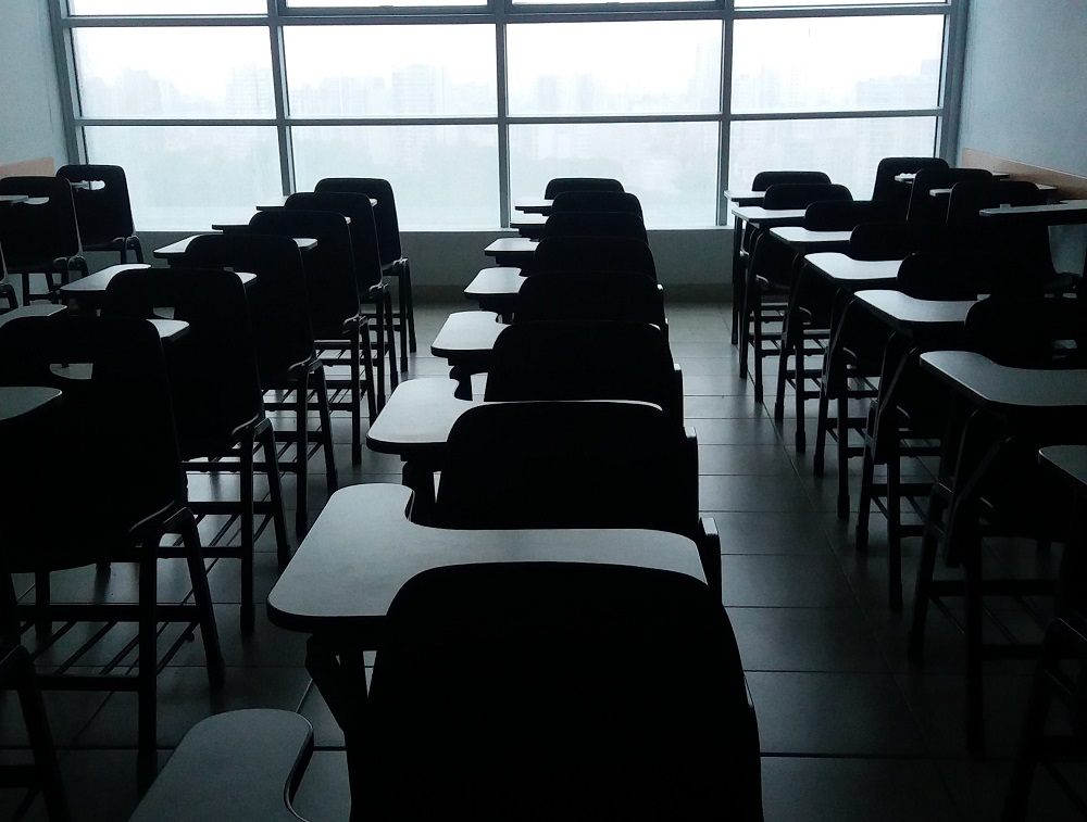 crno-bijela fotografija učionice sa školskim klupama