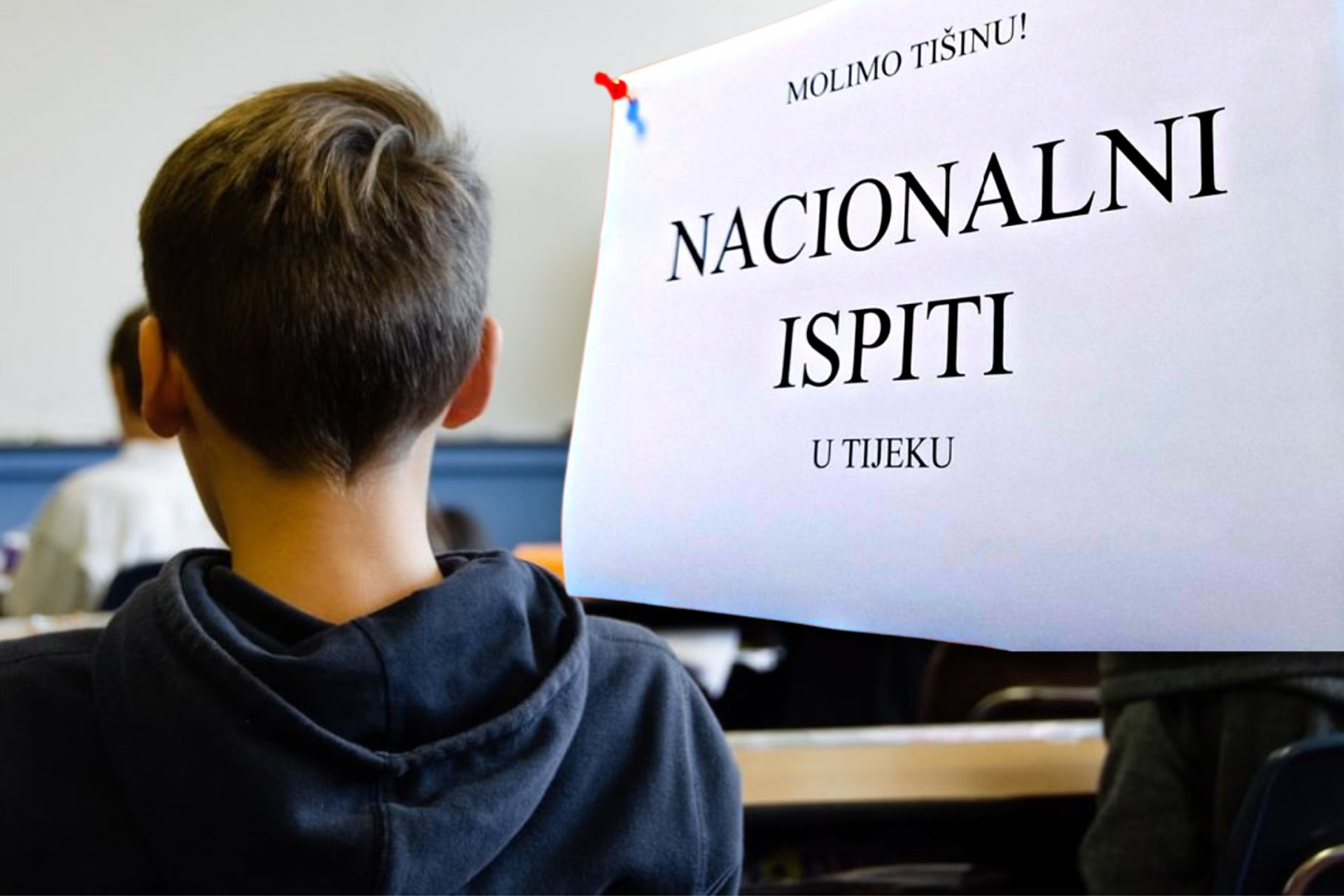 Učenik u učionici, papir na kojemu piše nacionalni ispiti