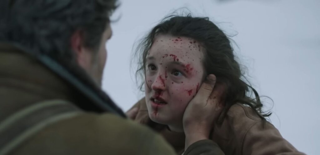 scena iz serije the last of us gdje je Elllie krvava lica i Joel joj drži ruku na licu
