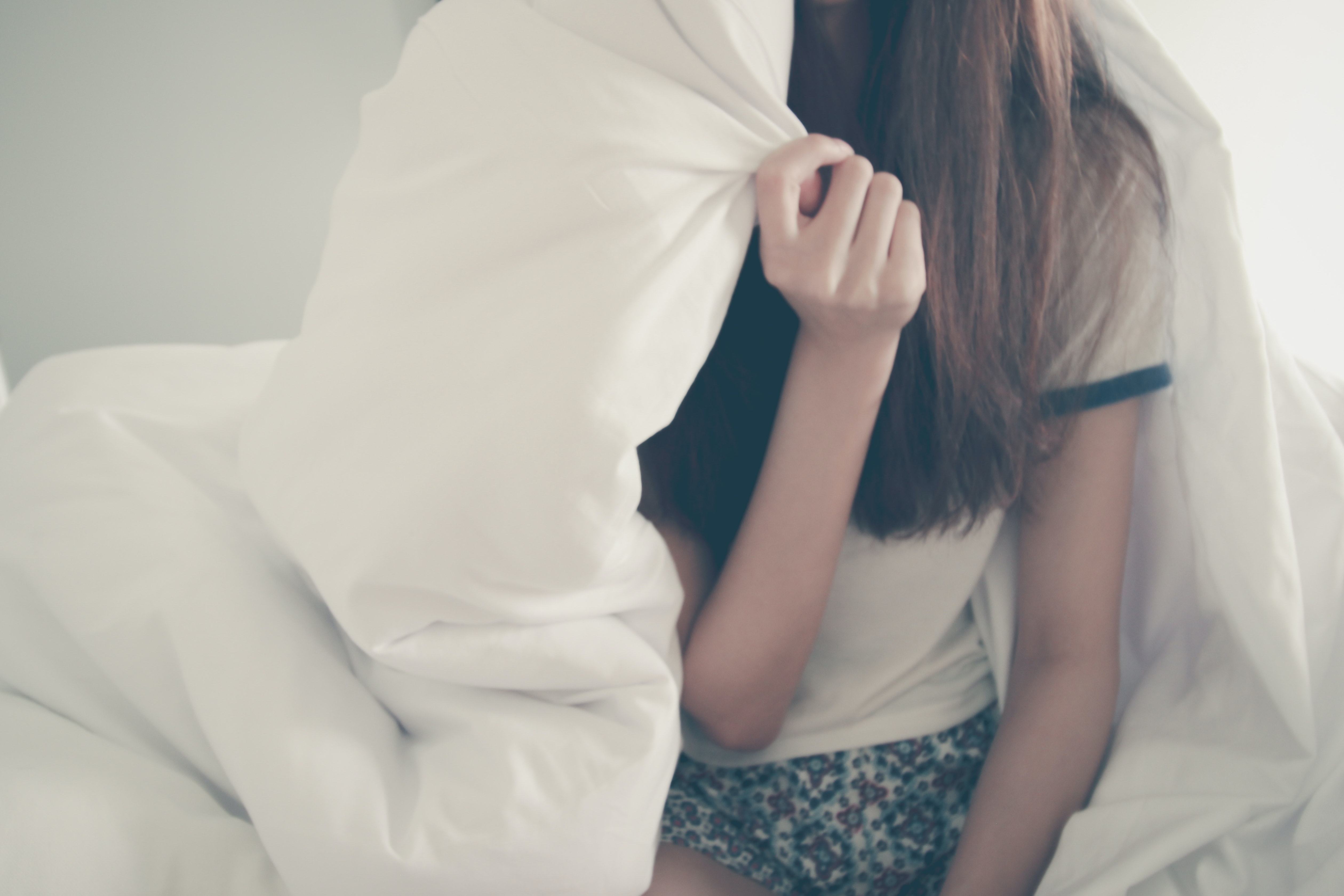 djevojka u pidžami na krevetu prekrivena s dekom
