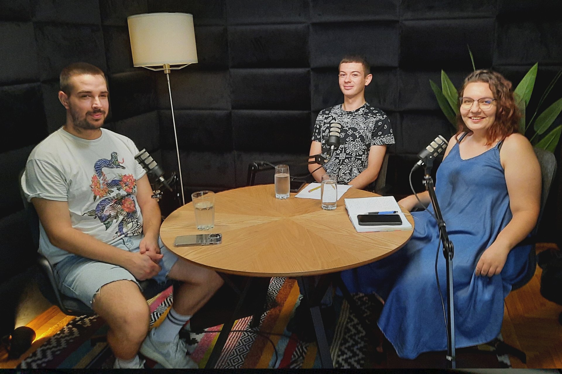 podcast studentski poslovi - Duje, Ramona i Hrvoje u studiju sa smeđim stolom, crnom pozadinom i lampom