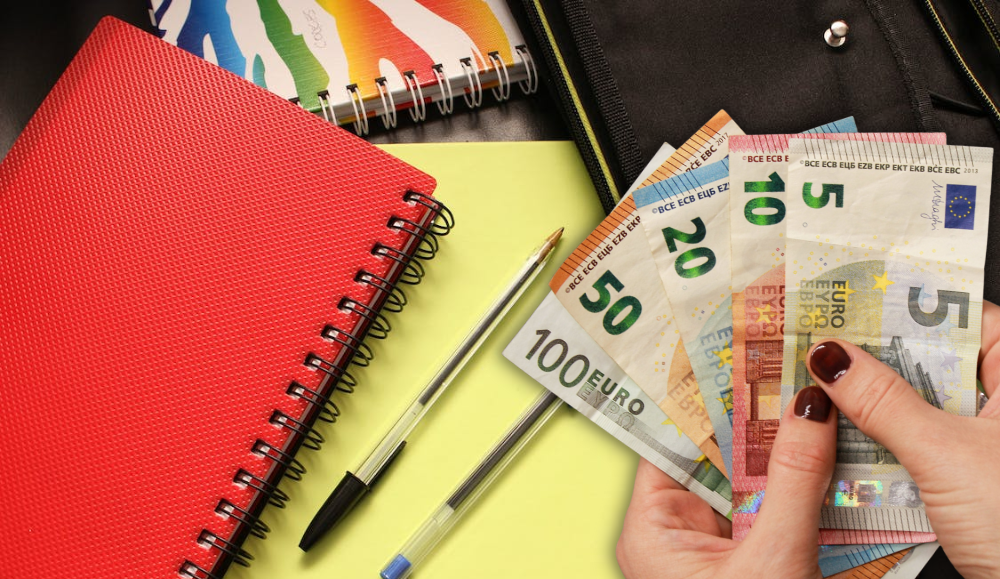 školski pribor olovka kemijska bilježnica i ruke koje drže eure