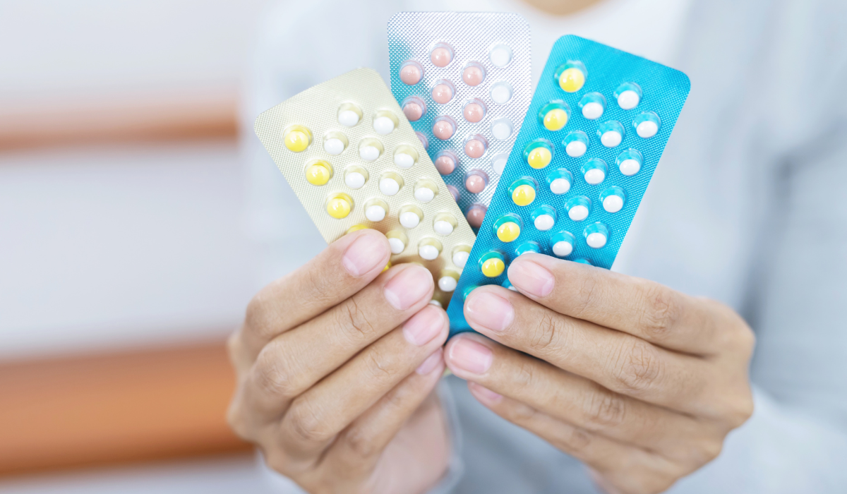 Ženska ruka koja drži kontracepcijske pilule