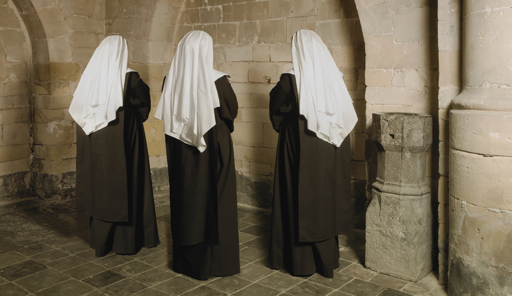 tri časne sestre stoje i mole se