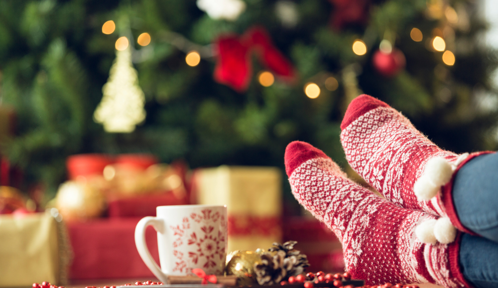 božićni praznici, zimske čarape i okićeni bor u pozadini