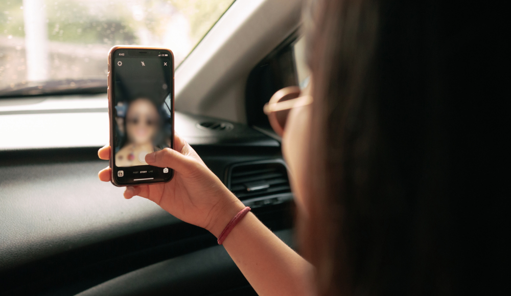 djevojka radi selfie na mobitelu u autu