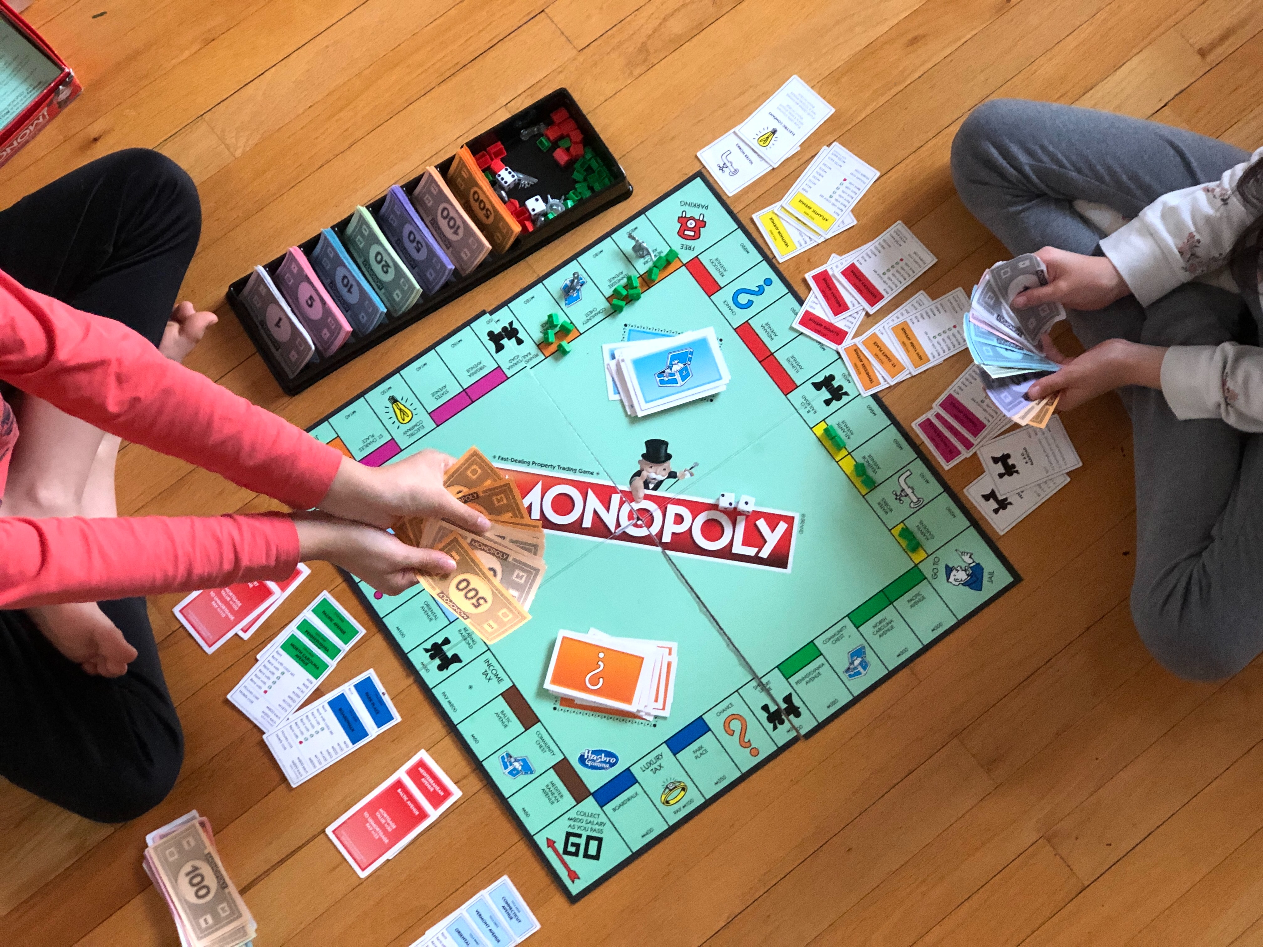 dvoje djece koji igraju igru monopoly